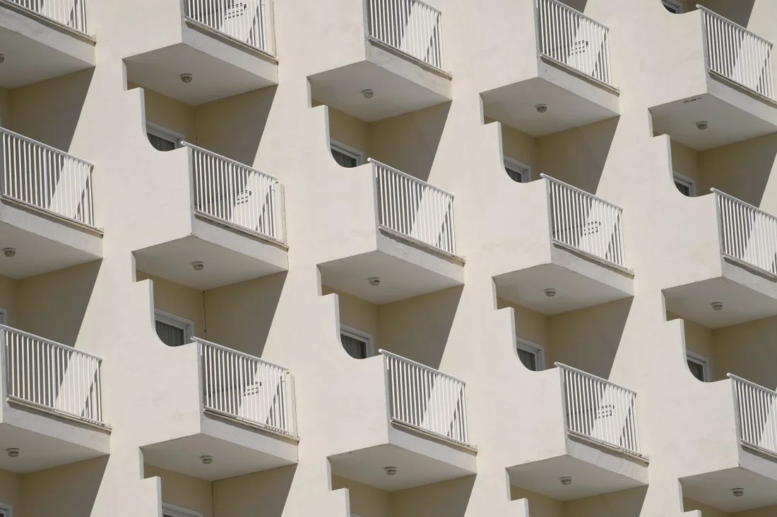 Fachada con decenas de balcones blancos idénticos en un edificio de viviendas