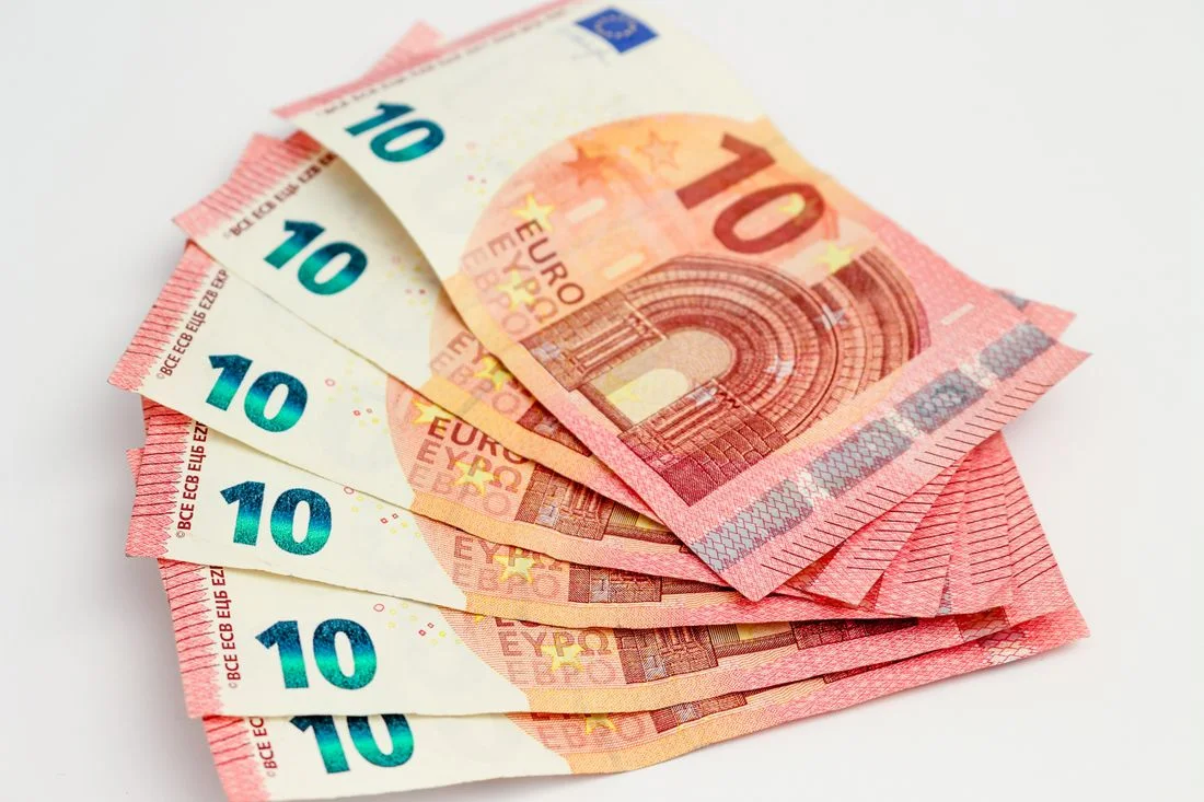 Billetes de diez euros extendidos sobre fondo blanco