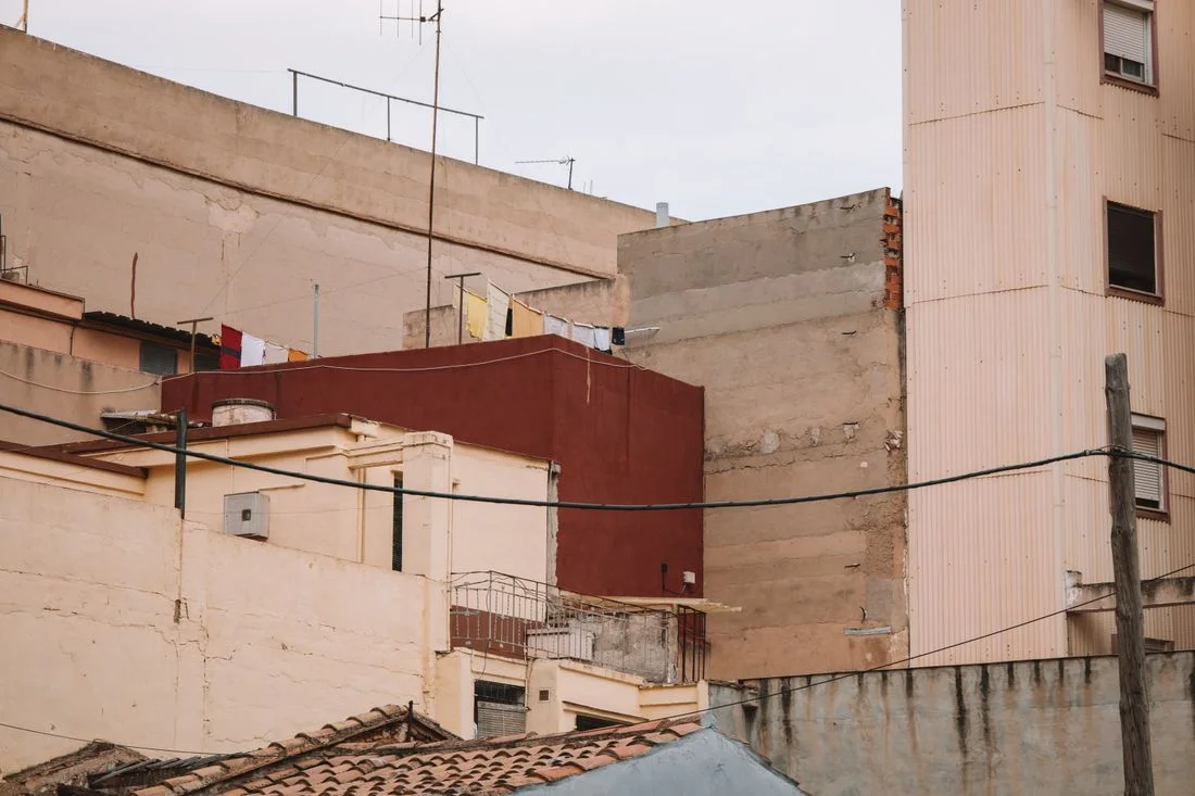 Traseras de edificios de un barrio español, con tendederos, medianeras y cables
