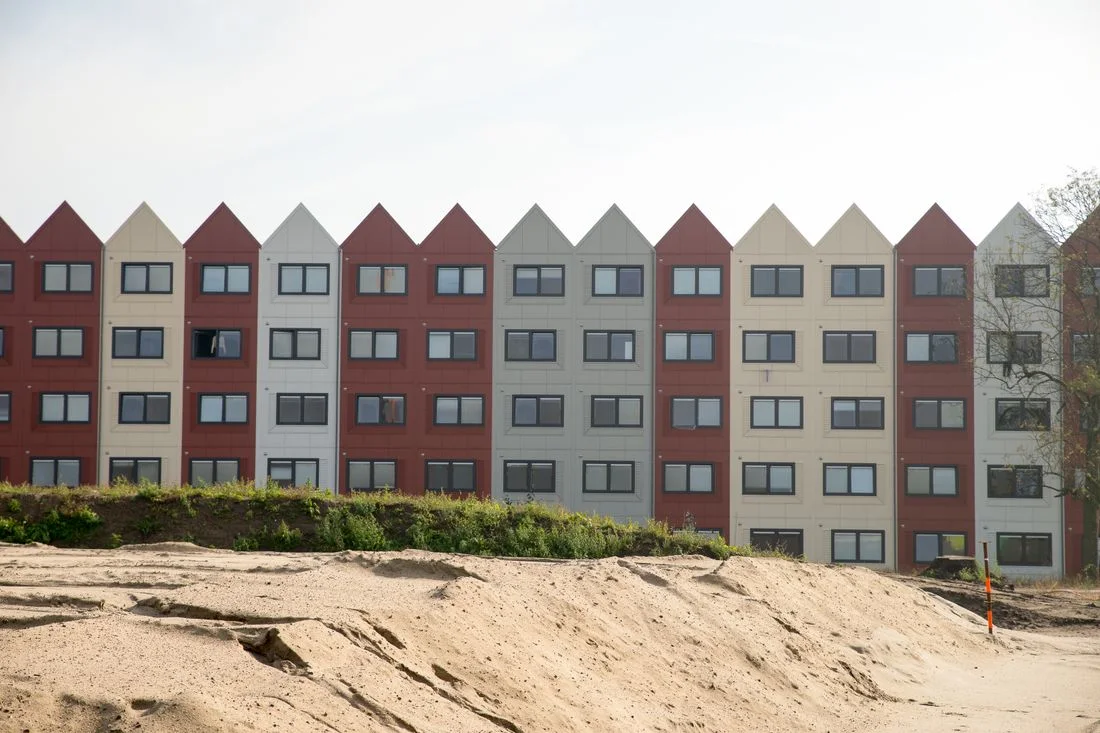 Hilera de bloques de viviendas nuevos al borde de un terreno en obras