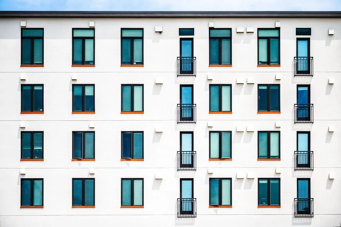 Fachada de un bloque de viviendas nuevo, con ventanas y balcones alineados
