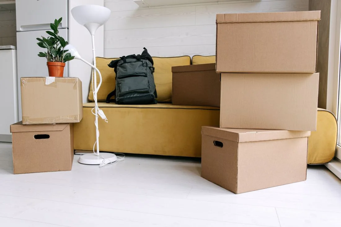 Cajas de cartón apiladas en el salón de una vivienda durante una mudanza