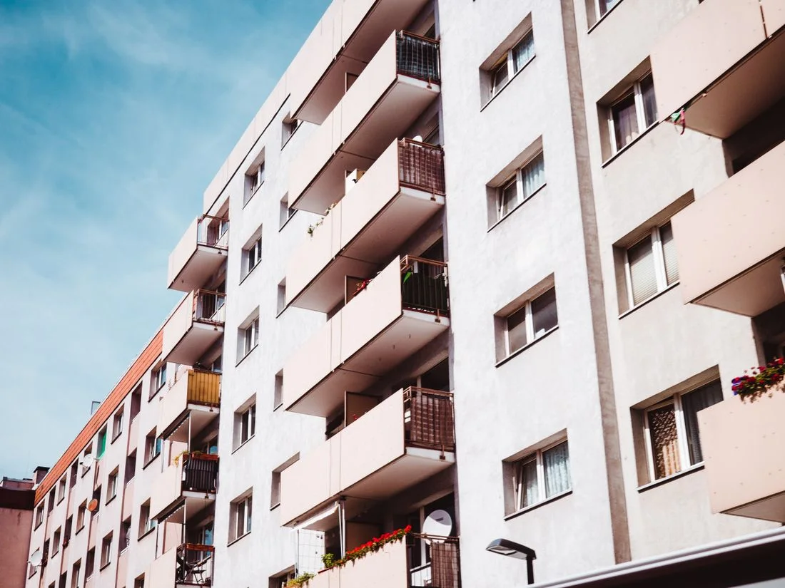 Bloque de viviendas urbano con balcones, persianas y plantas en las terrazas