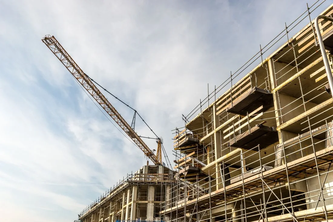 Edificio residencial en construcción, con grúa y andamios montados