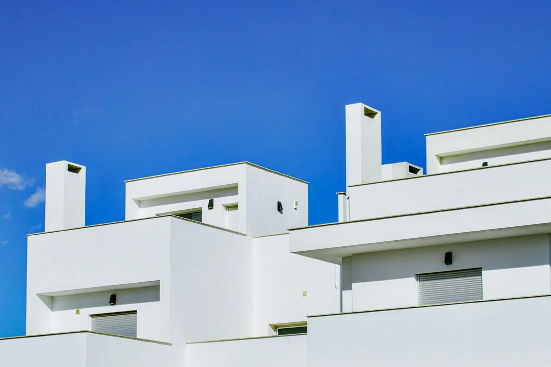 Bloque de vivienda de obra nueva en España, de fachada blanca y balcones