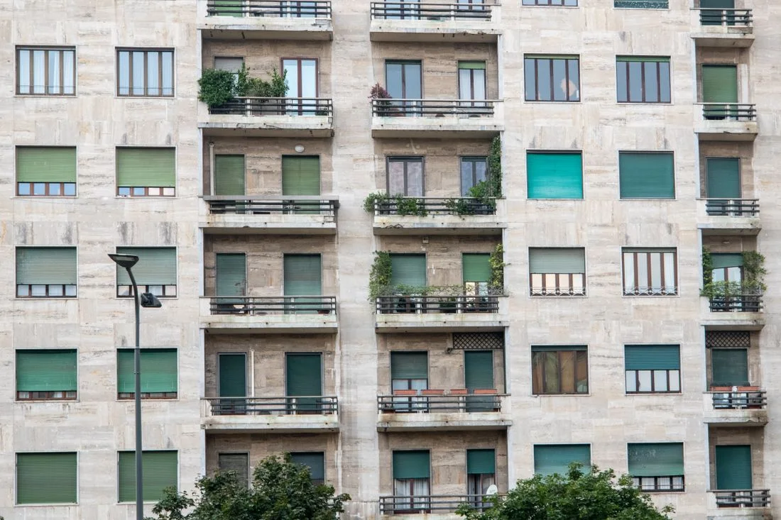 Fachada de un bloque de viviendas con balcones y persianas