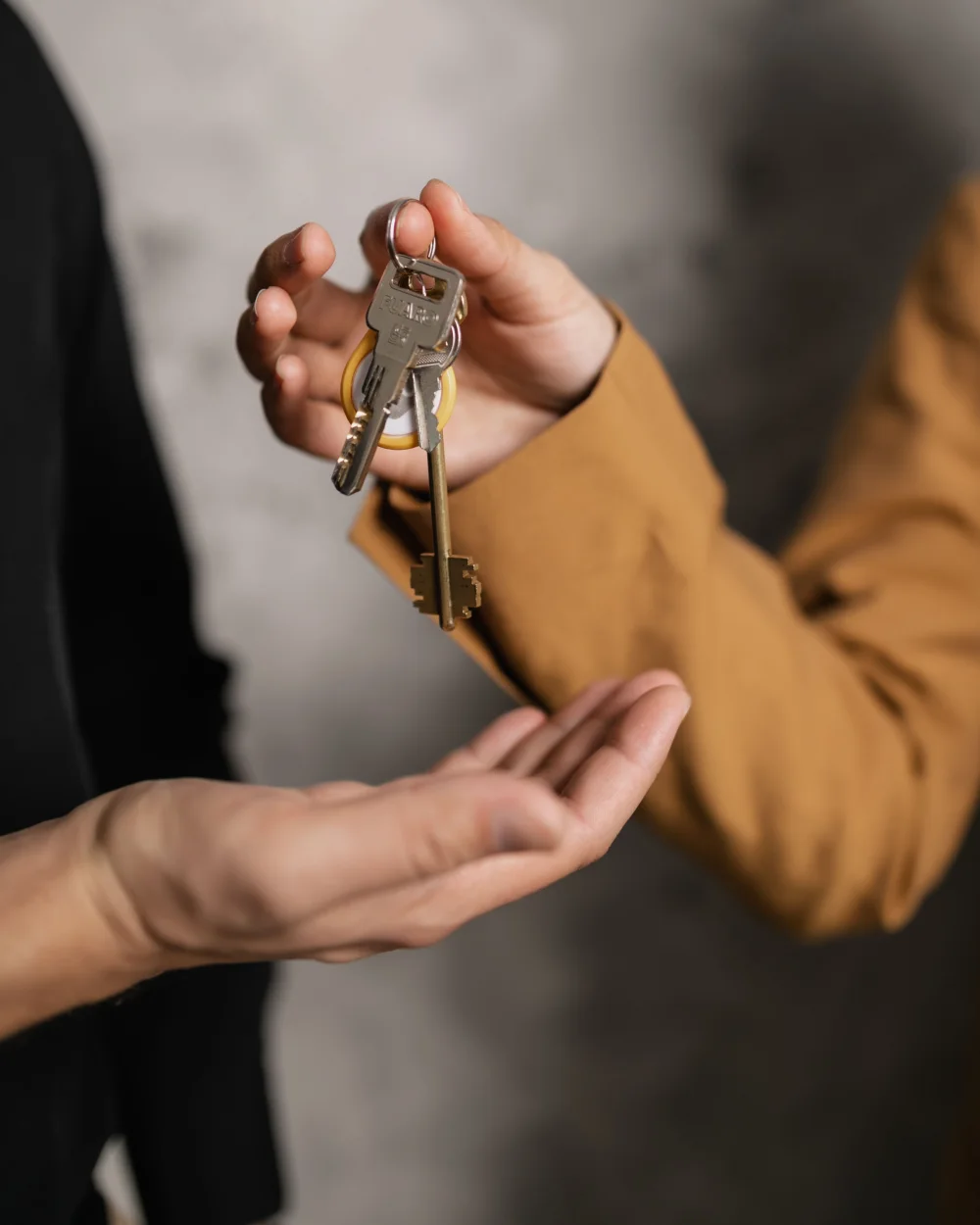Una mano entrega las llaves de una vivienda a otra que las recibe
