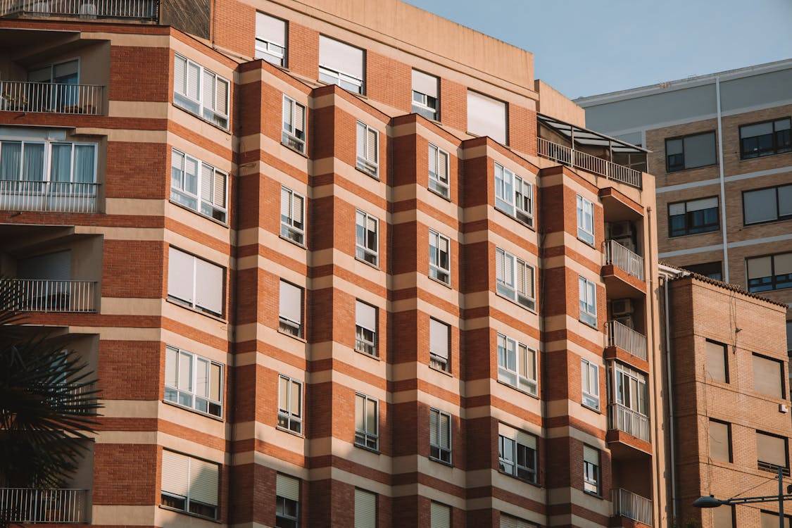 Documento del Plan Estatal Vivienda 2026-2030 junto a edificio de VPO en Madrid